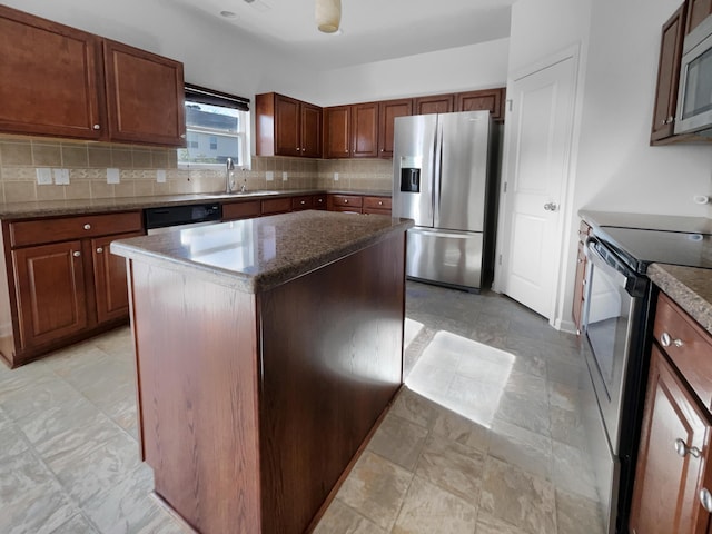 kitchen with sink, decorative backsplash, dark stone countertops, appliances with stainless steel finishes, and a kitchen island