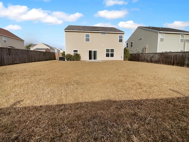 back of property with central AC unit and a lawn