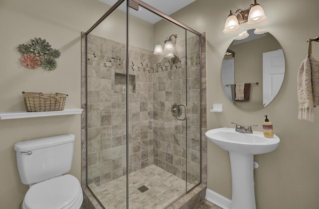 bathroom with sink, a shower with shower door, and toilet