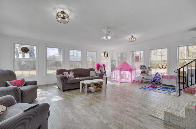 living room featuring light hardwood / wood-style flooring, an AC wall unit, and ceiling fan