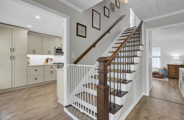 stairway with hardwood / wood-style flooring and ornamental molding