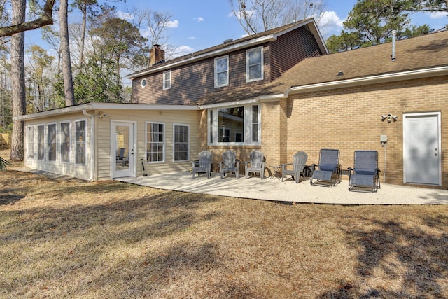 rear view of house featuring a patio and a lawn