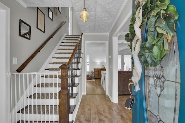 entrance foyer with hardwood / wood-style floors and ornamental molding