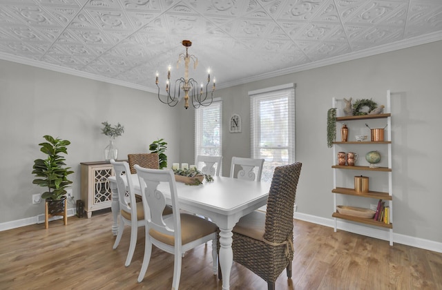 dining space featuring an inviting chandelier, ornamental molding, and wood-type flooring