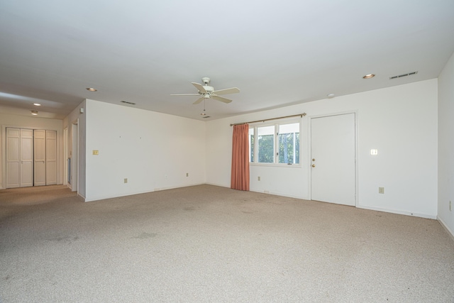 empty room featuring ceiling fan and carpet