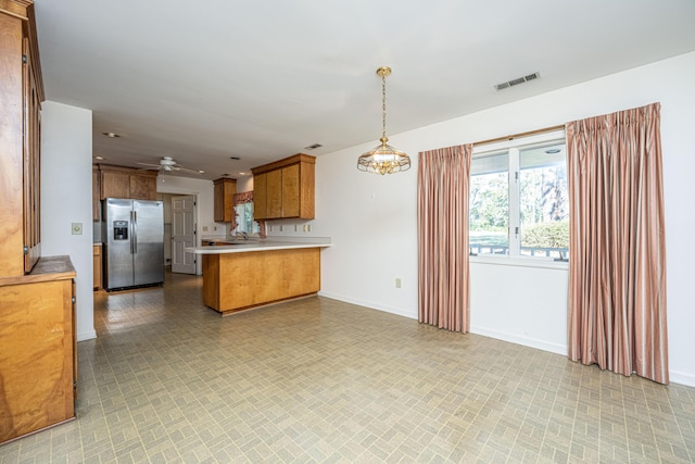 kitchen featuring kitchen peninsula, stainless steel fridge with ice dispenser, ceiling fan, and pendant lighting