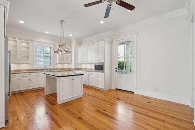 kitchen featuring white cabinets, light wood-style floors, a center island, and appliances with stainless steel finishes