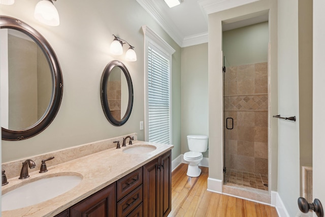full bath featuring toilet, crown molding, a sink, and a shower stall