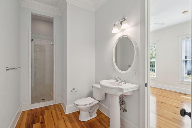 bathroom with toilet, crown molding, wood finished floors, and a shower stall