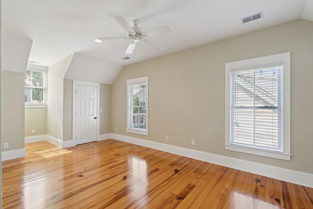 bonus room with light wood-style floors, a healthy amount of sunlight, vaulted ceiling, and visible vents