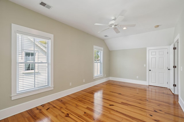 interior space featuring ceiling fan, visible vents, lofted ceiling, light wood finished floors, and baseboards