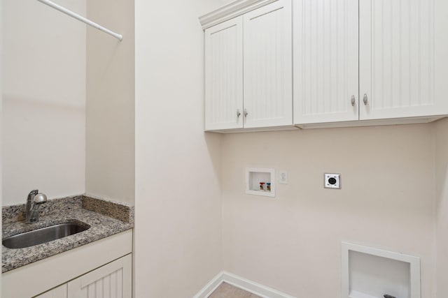 washroom with baseboards, electric dryer hookup, washer hookup, cabinet space, and a sink