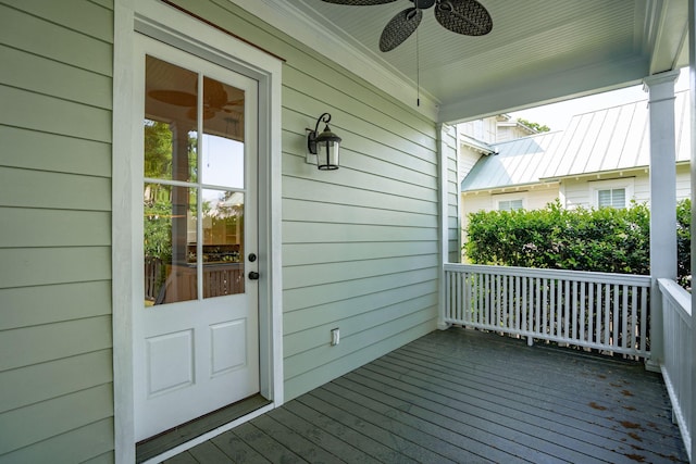 wooden terrace featuring covered porch and a ceiling fan