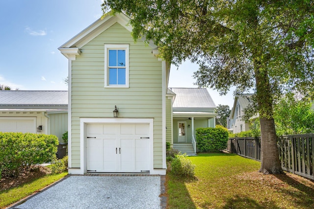 traditional-style home with an attached garage, fence, driveway, and a front lawn