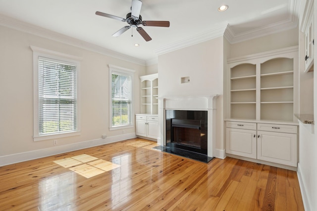 unfurnished living room with a fireplace, light wood-type flooring, baseboards, and ornamental molding