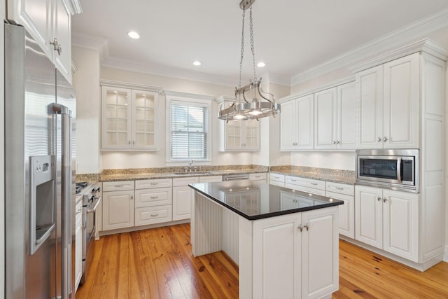 kitchen featuring light wood-style floors, a sink, white cabinetry, and stainless steel appliances