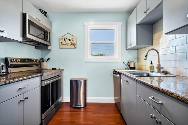 123 Jungle Rd, Edisto Island, SC 29438 - kitchen with stainless steel appliances, gray cabinetry, dark wood finished floors, tasteful backsplash, and dark stone counters