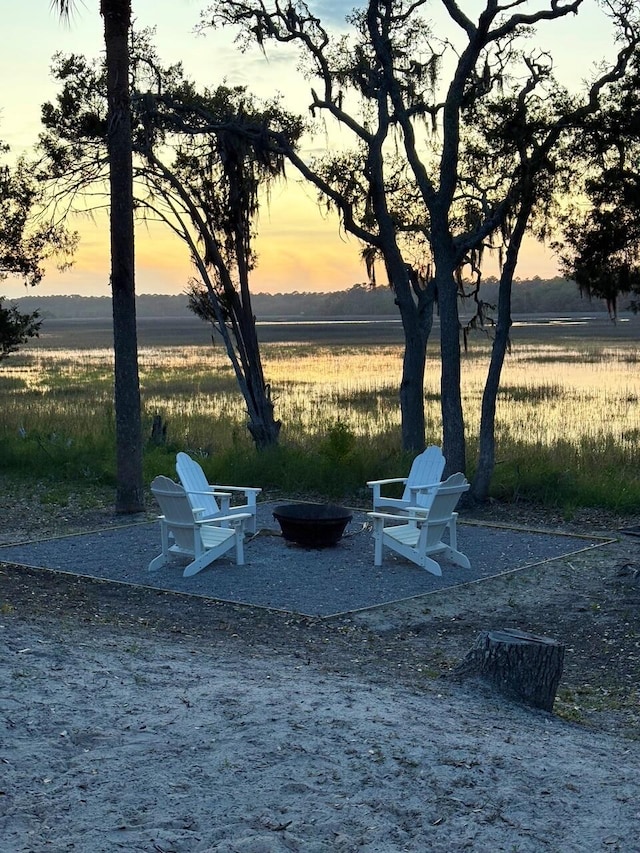 123 Jungle Rd, Edisto Island, SC 29438 - patio terrace at dusk featuring an outdoor fire pit