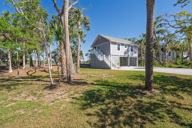 123 Jungle Rd, Edisto Island, SC 29438 - view of grassy yard with stairway, a garage, and driveway