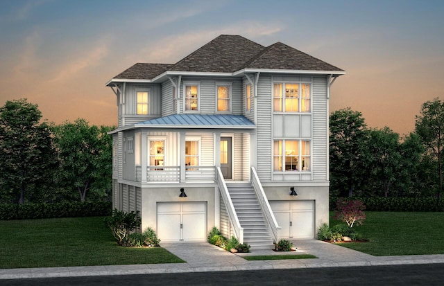 beach home with driveway, a yard, stairs, and stucco siding