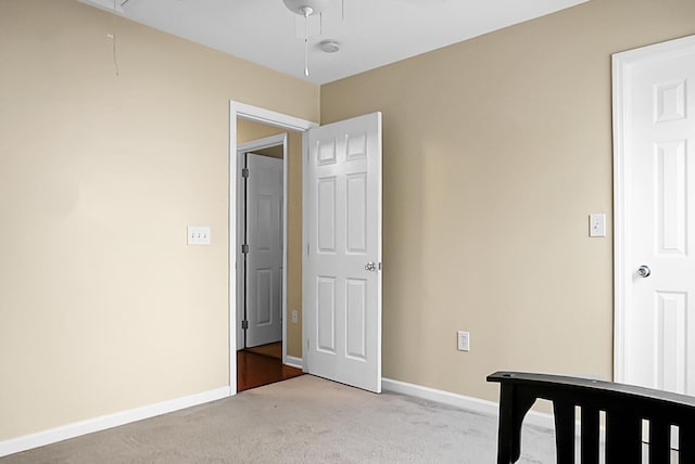 bedroom with baseboards, attic access, and light carpet