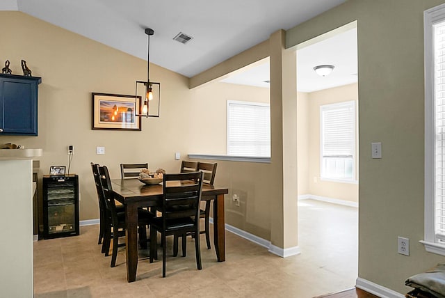 dining area with visible vents, baseboards, light tile patterned floors, and vaulted ceiling