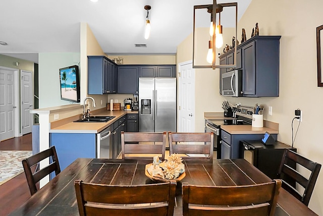 kitchen with visible vents, light countertops, a sink, appliances with stainless steel finishes, and decorative light fixtures