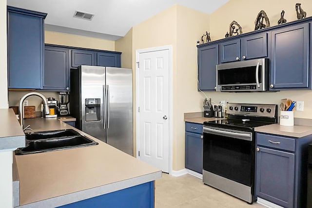 kitchen featuring a sink, light countertops, stainless steel appliances, visible vents, and blue cabinets
