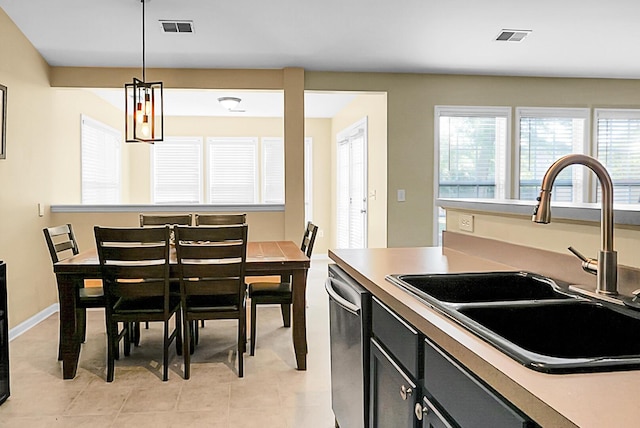 kitchen with stainless steel dishwasher, visible vents, dark cabinetry, and a sink