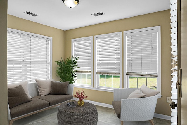 living area with baseboards and visible vents