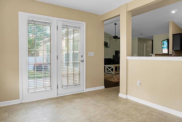 doorway to outside featuring baseboards and ceiling fan