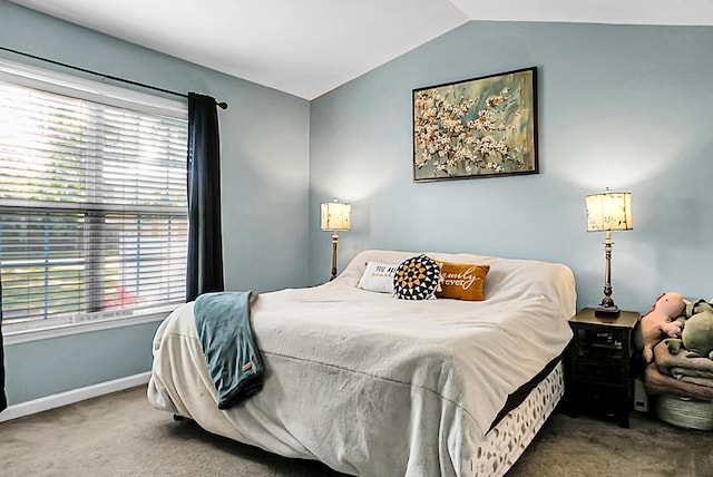 bedroom with carpet floors, vaulted ceiling, and multiple windows