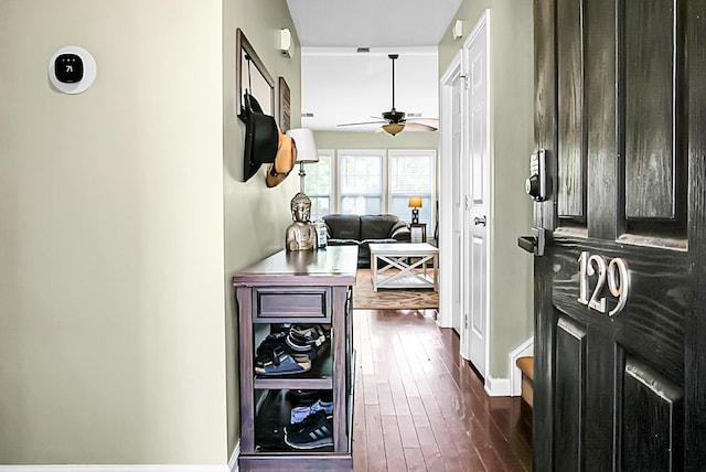corridor featuring baseboards and dark wood finished floors