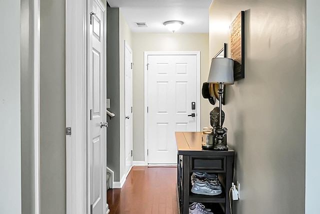 doorway with visible vents, baseboards, and dark wood-style floors