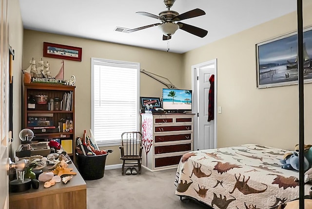 carpeted bedroom with visible vents, a ceiling fan, and baseboards