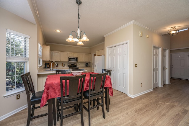 dining room featuring a textured ceiling, a notable chandelier, crown molding, and light hardwood / wood-style flooring