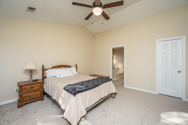 bedroom featuring ceiling fan, ensuite bathroom, light colored carpet, a textured ceiling, and vaulted ceiling