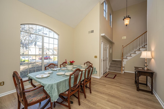 7011 Windmill Creek Rd, Charleston, SC 29414 - dining space with high vaulted ceiling, light wood-type flooring, and stairs