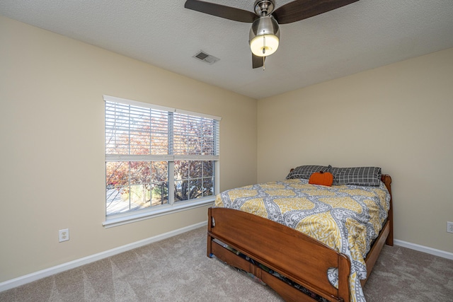 bedroom with carpet flooring, ceiling fan, and a textured ceiling