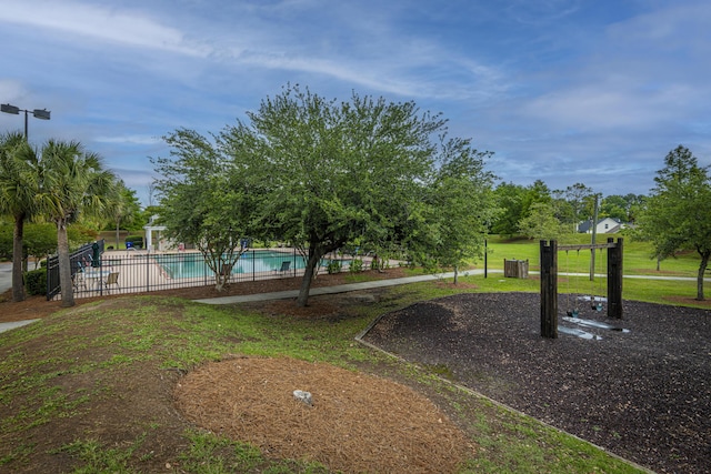 view of community featuring a lawn, a patio, and a pool