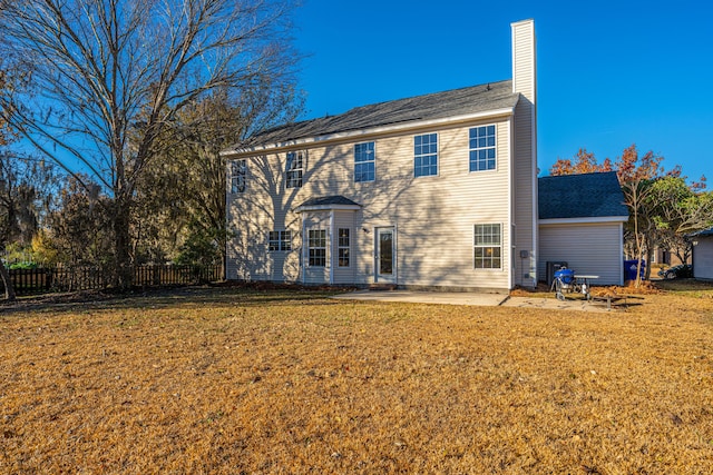 back of house with a lawn and a patio