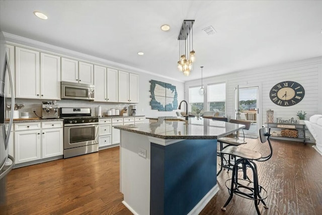 kitchen featuring white cabinetry, appliances with stainless steel finishes, sink, and a center island with sink