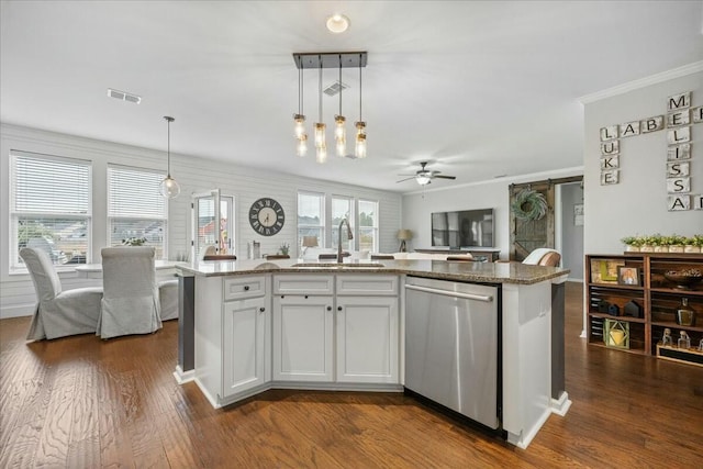 kitchen featuring a barn door, pendant lighting, sink, and stainless steel dishwasher