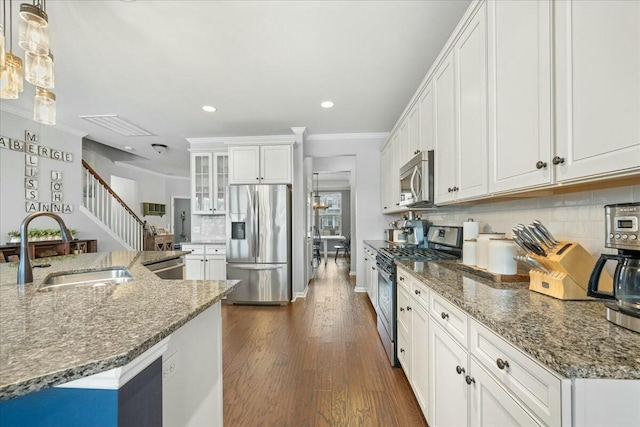 kitchen with sink, tasteful backsplash, decorative light fixtures, stainless steel appliances, and white cabinets