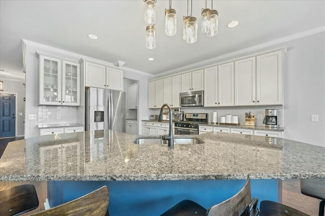 kitchen featuring sink, appliances with stainless steel finishes, white cabinetry, a spacious island, and decorative light fixtures