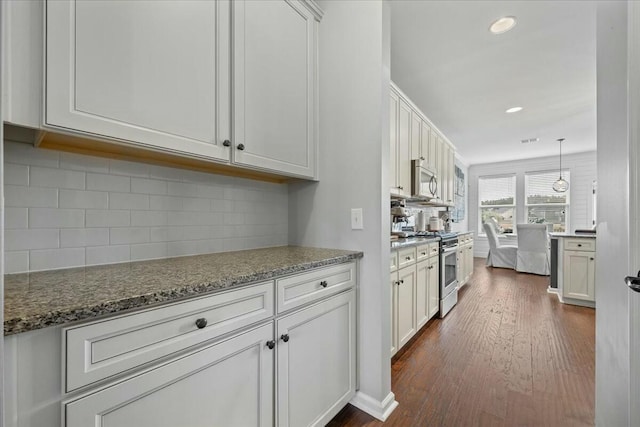 kitchen with white cabinetry, hanging light fixtures, stainless steel appliances, tasteful backsplash, and dark hardwood / wood-style flooring