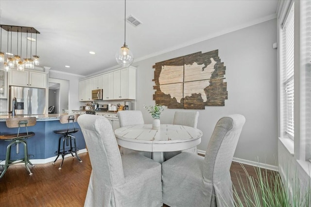 dining space featuring ornamental molding, dark hardwood / wood-style floors, and sink