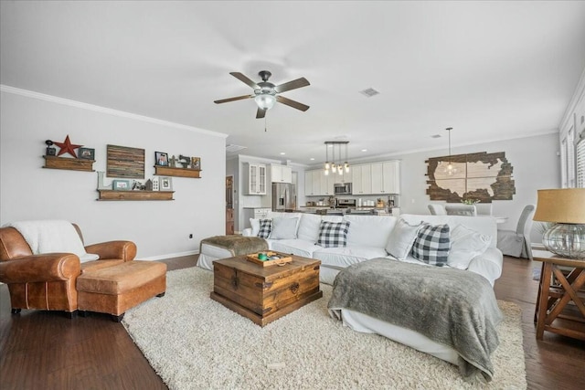 living room featuring dark wood-type flooring, ornamental molding, and ceiling fan