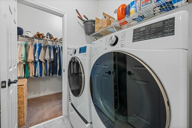 laundry area featuring light tile patterned flooring and washing machine and clothes dryer