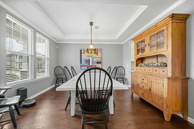 dining area with dark hardwood / wood-style flooring and a tray ceiling